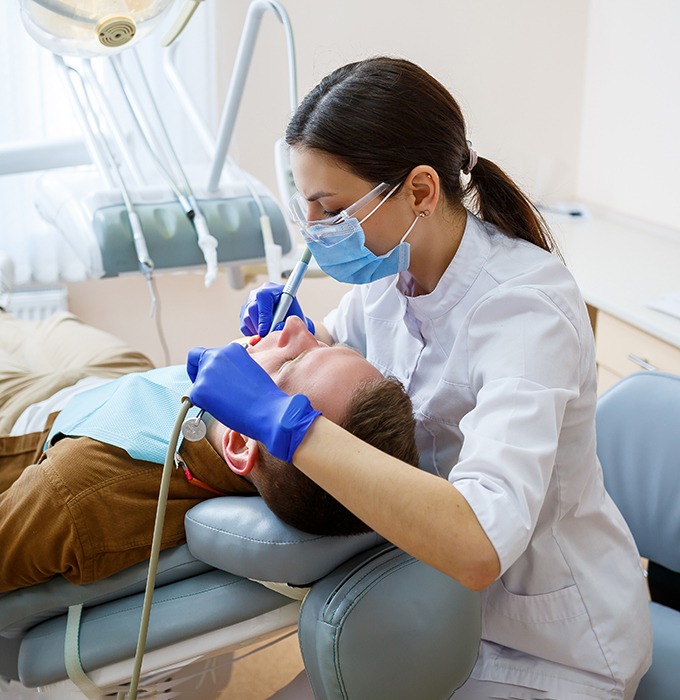 a person getting their teeth cleaned at the dentist’s office